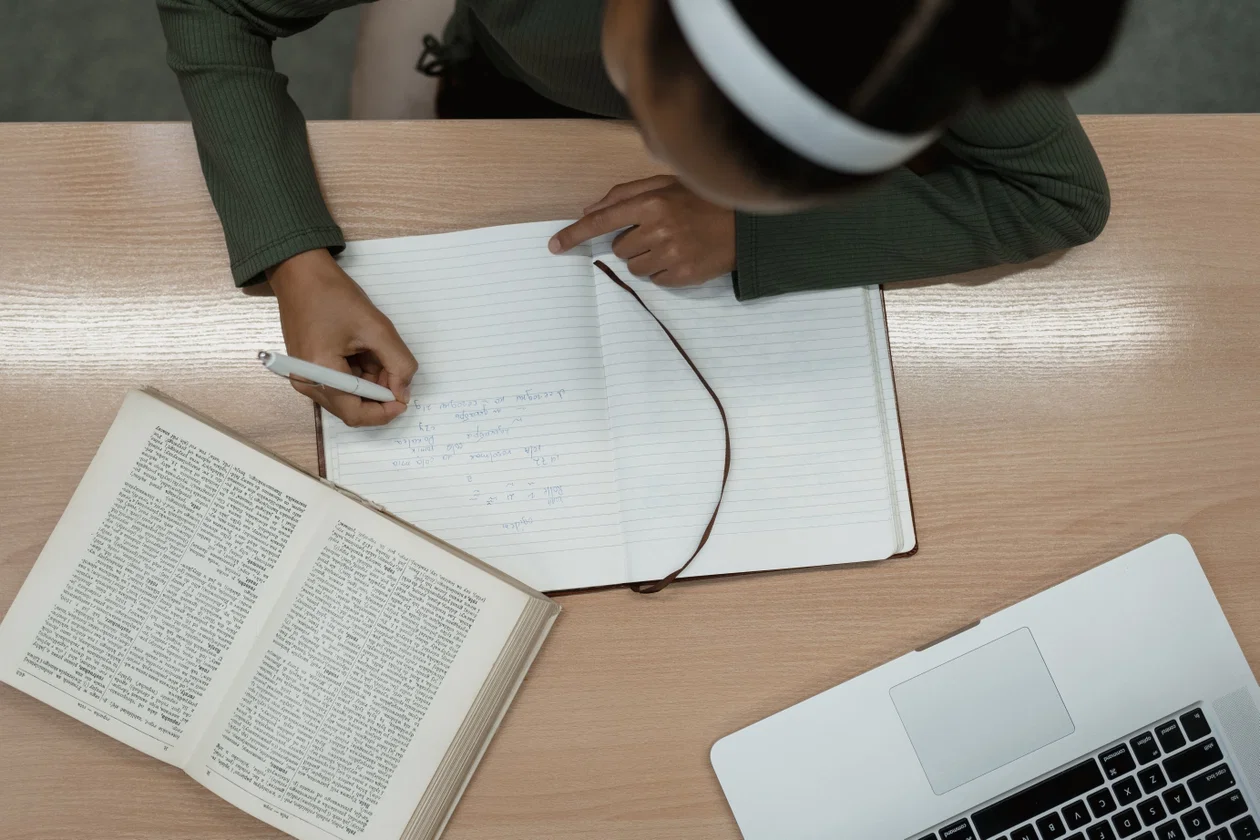 Girl writing carefully in a notebook preparing for a test