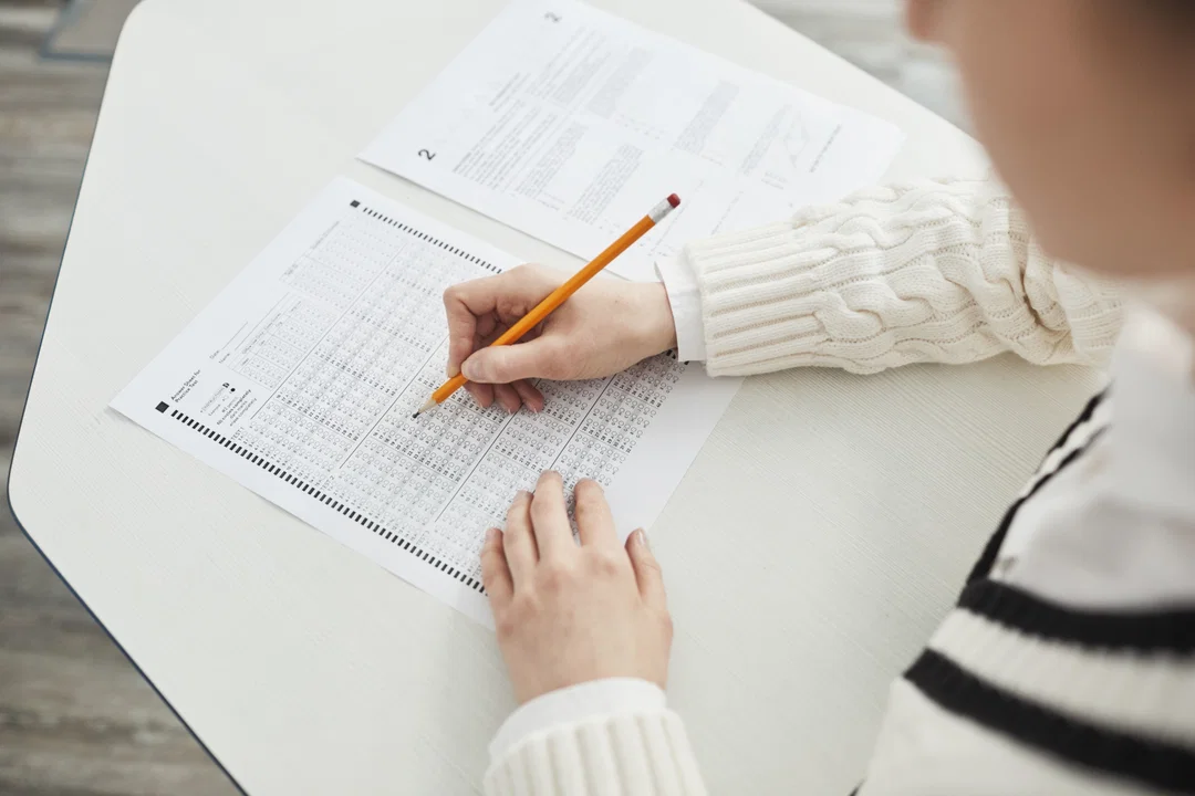 Student taking exam with pencil and test paper