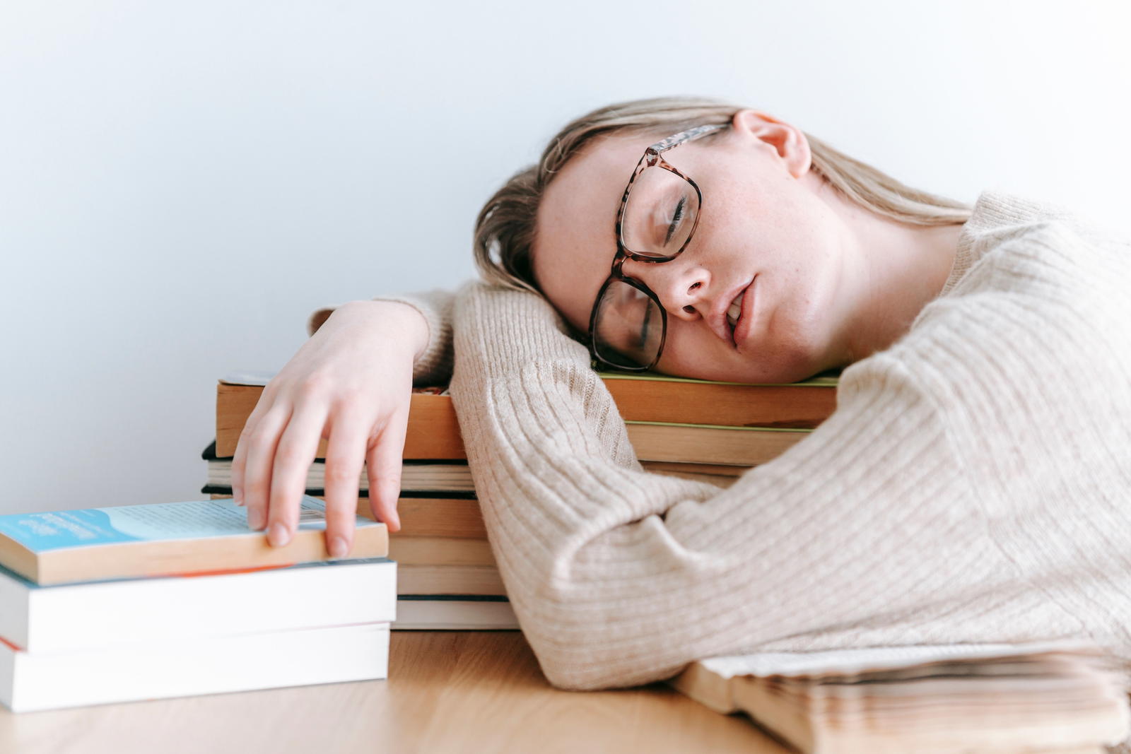 Tired student exhausted from studying with books