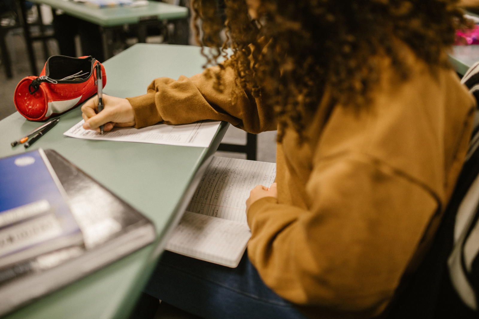 Student writing focused notes before an exam