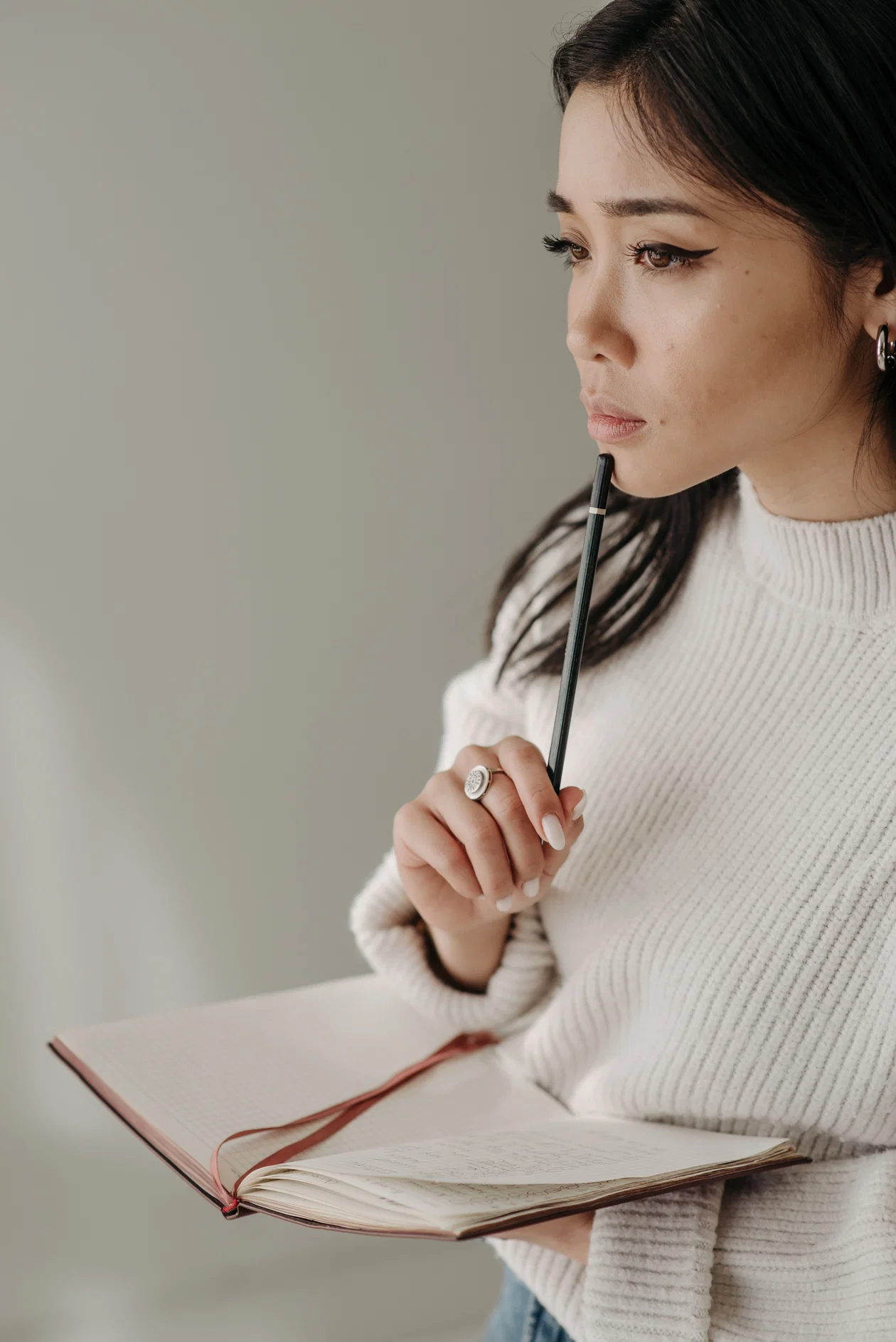 Woman holding a notepad and pen preparing for a speaking test