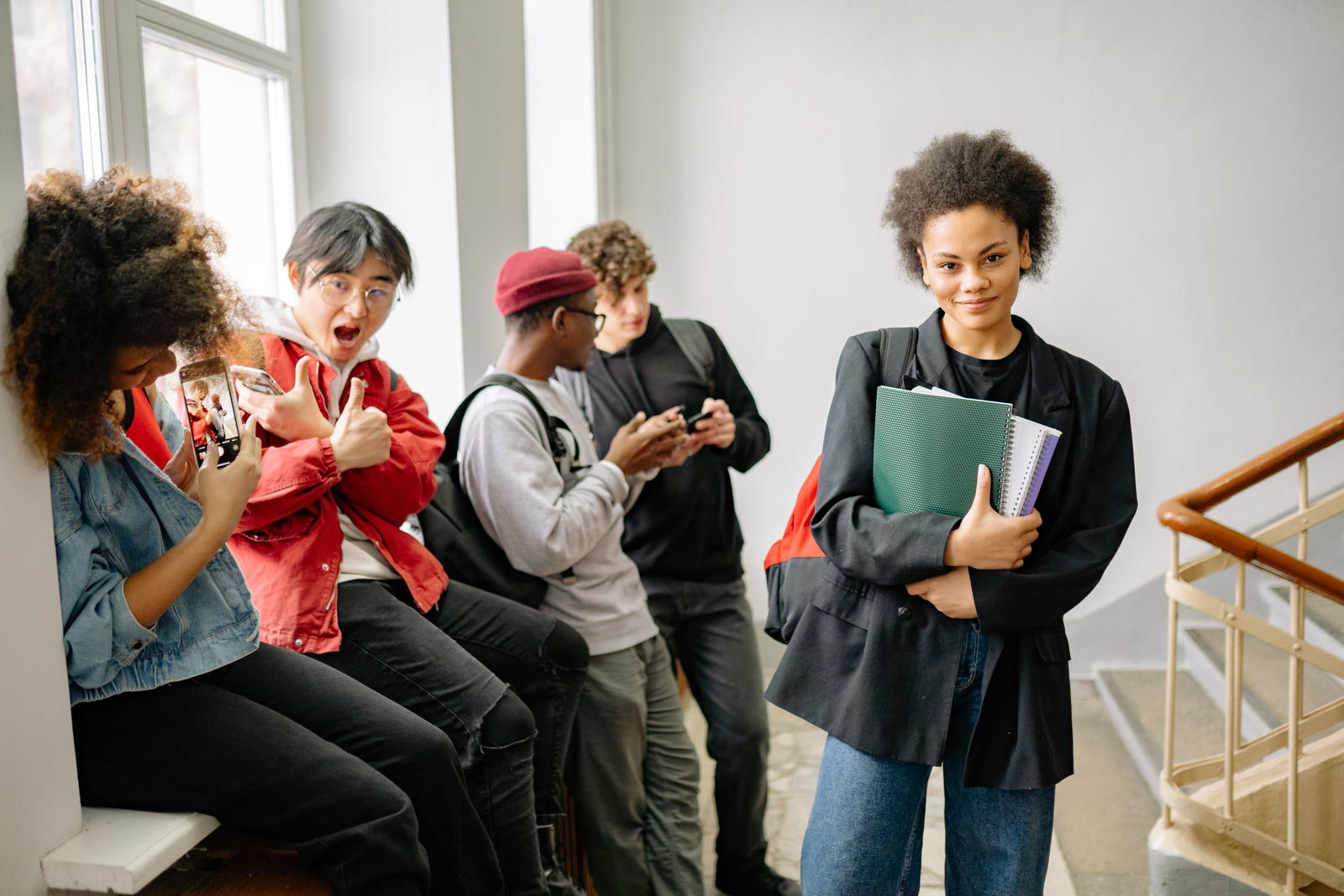 Diverse college students chatting in university hallway