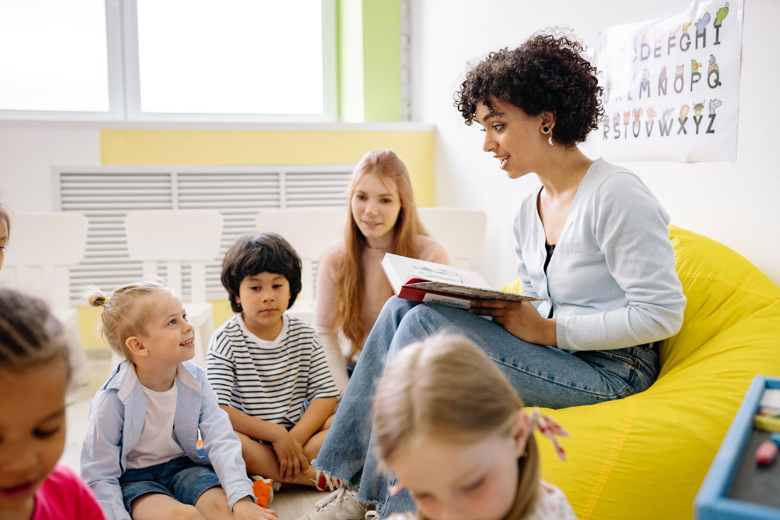Parent and child learning English together with books and tablet at home