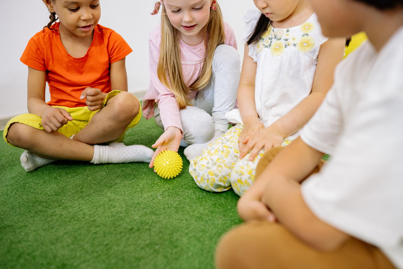 Young child learning phonics with colorful letters and teacher guidance